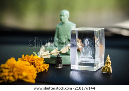 Close up image of crystal statue of the Buddha place in the car for good luck on the road or trip