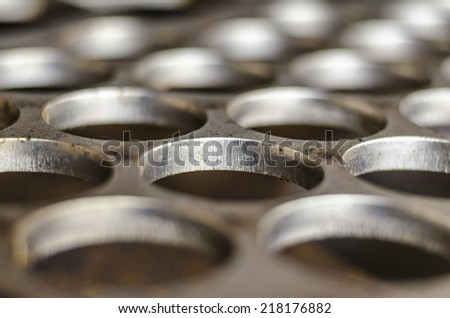 Close up image of holes on stainless steel plate made by plasma cutting machine