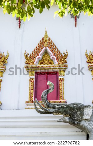 A concrete elephant sculpture in temple which have window of church as back ground, Thailand