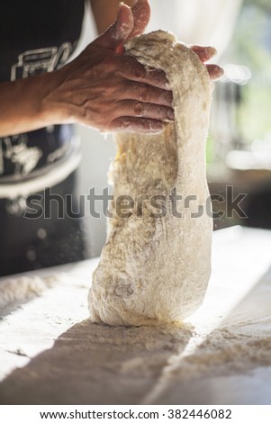 woman kneads raw dough by hand
