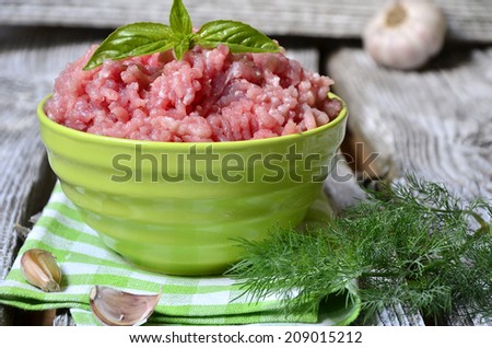 Ground meat in a bowl on the rustic background.
