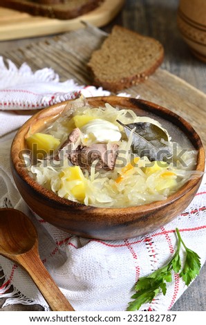 Rustic sour cabbage soup with goose in a wooden bowl.Traditional russian,belorussian and ukrainian dish.