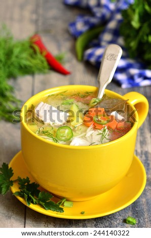 Chicken soup with vermicelli in a yellow cup.