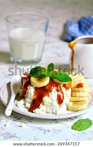 Cottage cheese with banana slices and caramel sauce for a breakfast.
