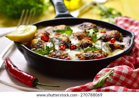 Fish meatball in tomato and spinach sauce with cheese baked in frying pan.