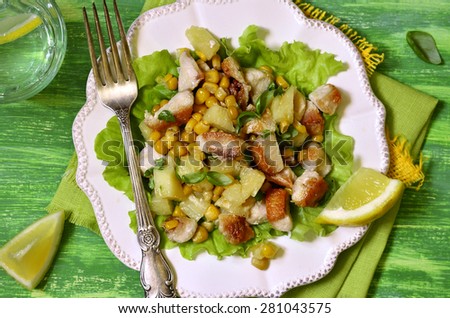 Salad with fried chicken,pineapple and sweet corn on green wooden table.