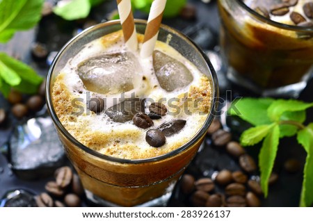 Iced coffee in a glass on black background.