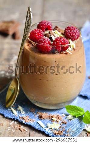 Chocolate mousse with raspberry in a glass.Rustic style.
