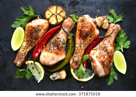 Grilled spicy chicken legs on a black background.Top view.