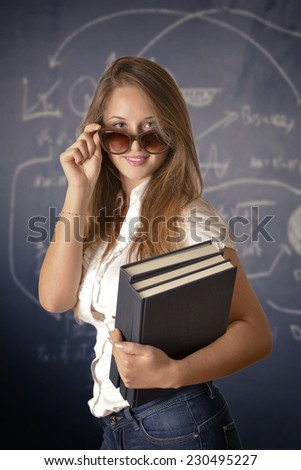 Portrait of a young woman, teacher in front of a blackboard