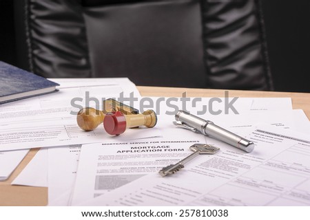 pen, key and stamps on mortgage application form