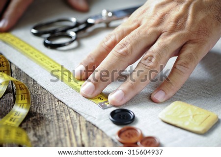 male tailor hands working with cloth fabric