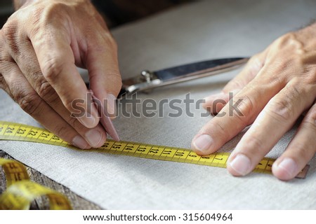 male tailor hands working with cloth fabric