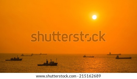 A Fleet of Fishing Boats, Oil Tankers and Cargo Ships Heading the Same Direction on the Sea Under Sunset, Captured at Kaohsiung Port, Taiwan.