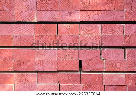Pile of Red Wooden Logs. Sliced in Rectangular Shape. Annual Rings Can Be Seem in the Cross Section. Used for Construction.