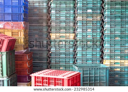 Plastic Pallets of Various Colors Pile Up Together And Form A Wall