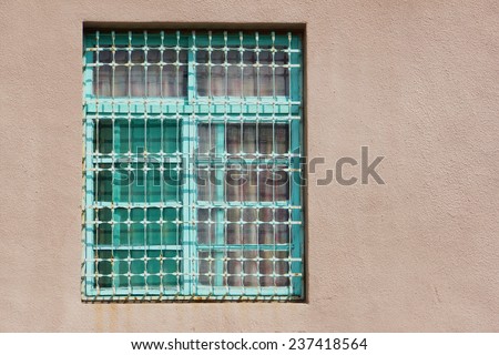 A Green  Wooden Window With Iron Bars on Stone Wall of Earth Color. An Typical Style of Window in Old Buildings in !970s of Taiwan.