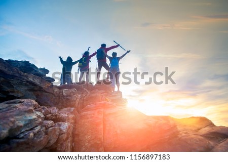 Male and female hikers climbing up  mountain cliff . helps and team work concept.