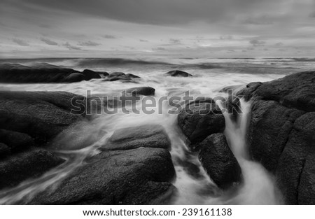 Sea waves hit the rocks black and white tone.