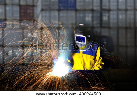Industrial worker cutting and welding metal with many sharp sparks,