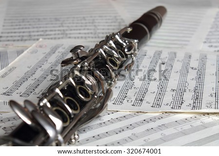 Old clarinet on the old grunge music notes close-up