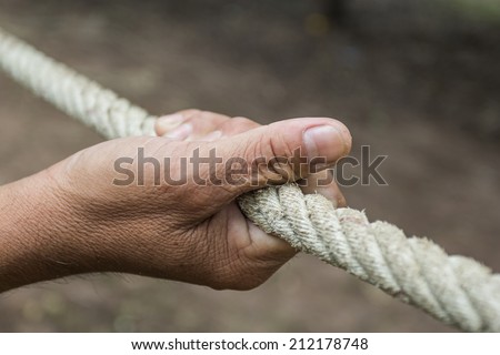 Hands of men with ropes to help pull rope.