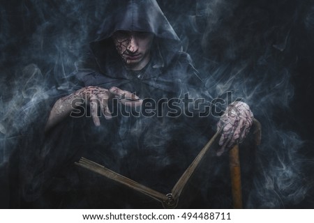 Necromancy sorcerer casting black magic spell using his book of shadows