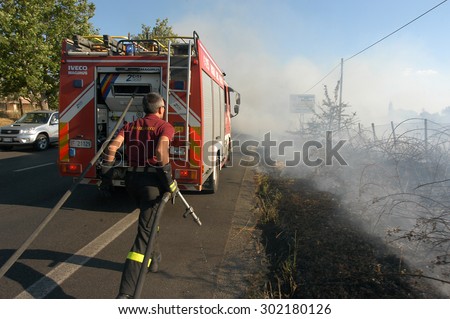Bracciano, Italy - July 14, 2005: Severe Fires destroy forest in Italy. Italian firefighters work surrounded by the smoke to extinguish the fire, July 14, 2005 in Bracciano, Lazio, Italy.