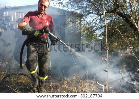 Bracciano, Italy - July 14, 2005: Severe Fires destroy forest in Italy. Italian firefighters work surrounded by the smoke to extinguish the fire, July 14, 2005 in Bracciano, Lazio, Italy.