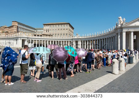 Vatican City - August 06, 2015: Long line of tourists in St. Peter\'s Square waiting to enter the basilica in the sun of summer in Rome. August 06, 2015
