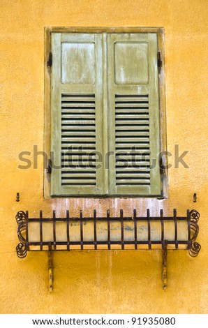 Shuttered window with green shutters closed