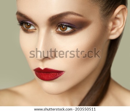 Beautiful model with fashion evening make-up and shiny skin . Smoky eyes. Red lips. Fashion beauty photo