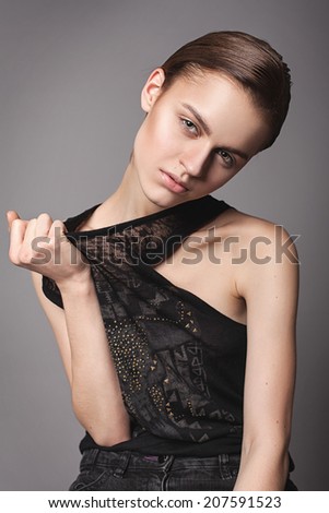 Beautiful young model with  natural make-up in black unisex clothes. Androgyne young woman