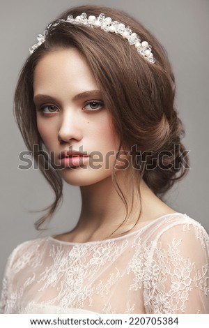 Portrait of the bride with beautiful make up and hairdo on gray background. Wedding trends