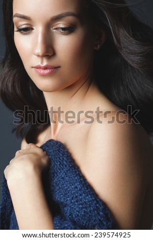 Beautiful woman with clean fresh skin and natural make-up on grey background.