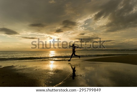 Runner silhouette running on the beach over ocean water at sunset.    water.