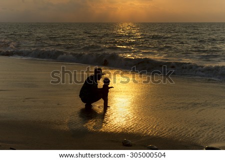 Father baby silhouette is a father lovingly showing his child the ocean for the very first time.