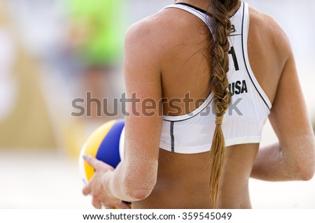 Volleyball player is a female athlete volley ball player getting ready to serve the ball.