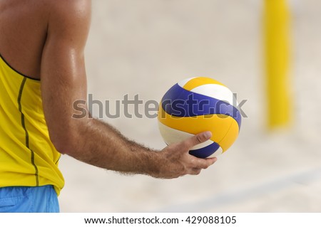 Volleyball player is a male athlete getting ready to serve the ball.