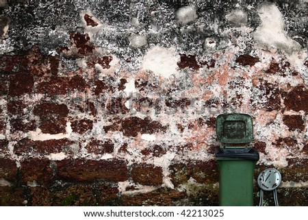Garbage bin and the rusted brick wall