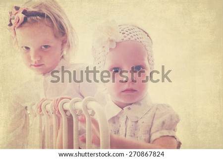 Art photo. Portrait of beautiful little girls (sisters)  in vintage style. The image is tinted, blurring and selective focus.