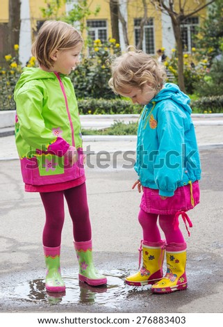 Beautiful little girls in the Park after the rain. Selective focus.