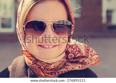 Beautiful little girl in a headscarf and sunglasses. The image is tinted.