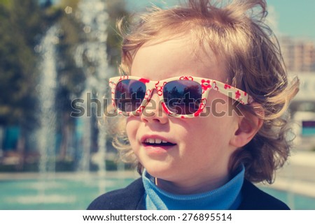 Beautiful little girl in sunglasses. The image is tinted.