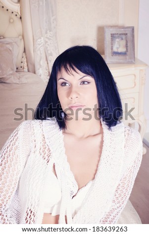 Pretty young woman on the sofa in beige-white colors