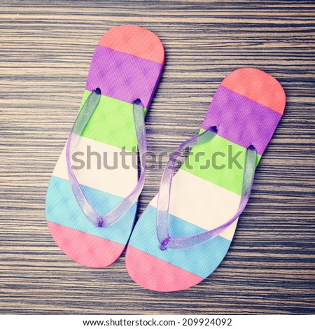 Pair of striped flip-flop  on wooden deck. Top view.
