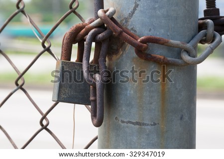 rusty old lock with rusty chain. lock the gate at junkyard.