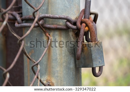 rusty old lock with rusty chain. lock the gate at junkyard.
