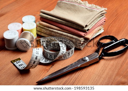 Close-up sewing tools on wooden background, vintage style