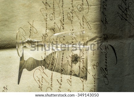 Vintage background with old paper, calligraphy handwriting letters and  liqueur glass with shadow